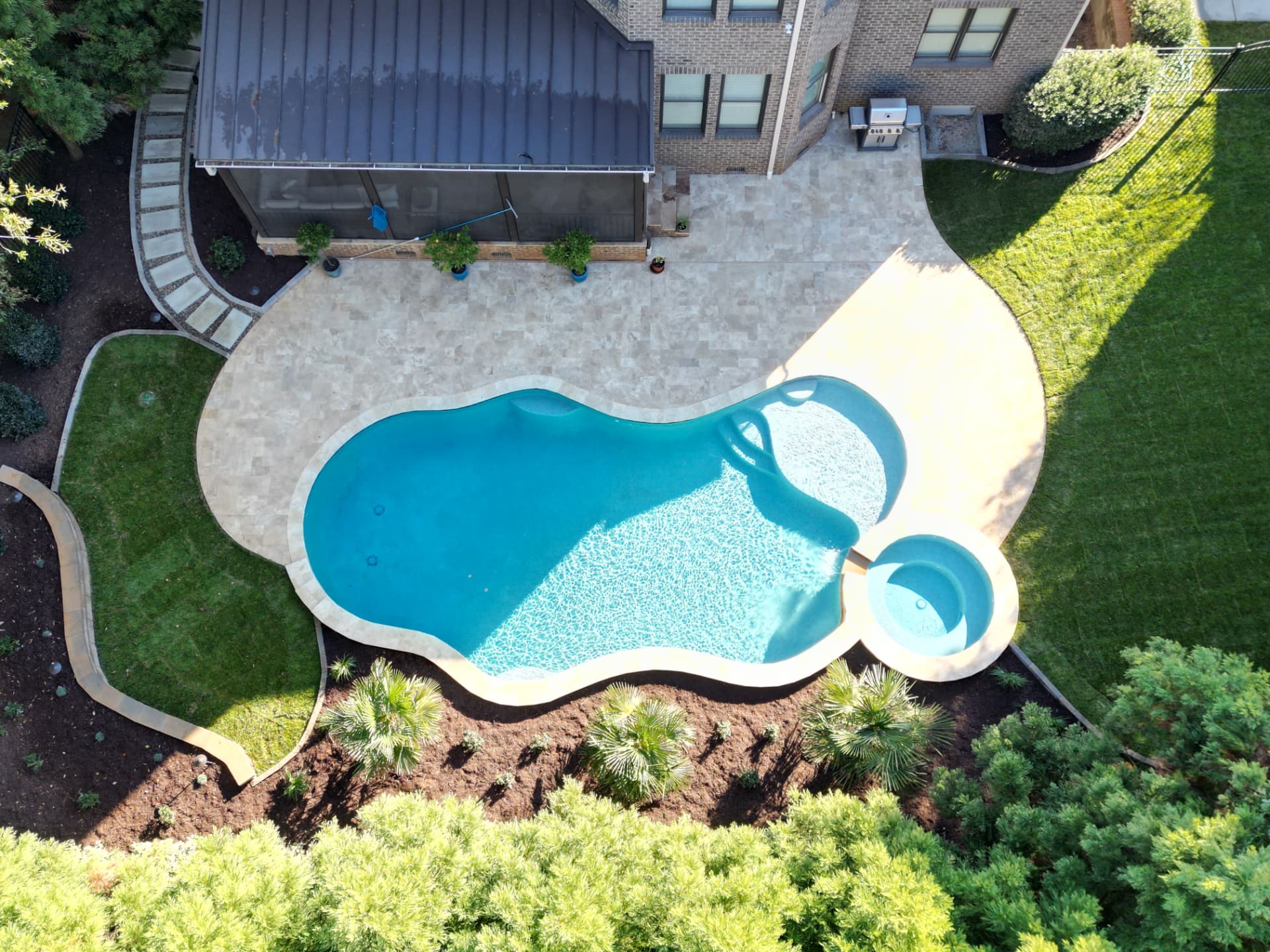 Aerial view of a custom pool, travertine patio, and landscaped backyard designed by JH Landscapes